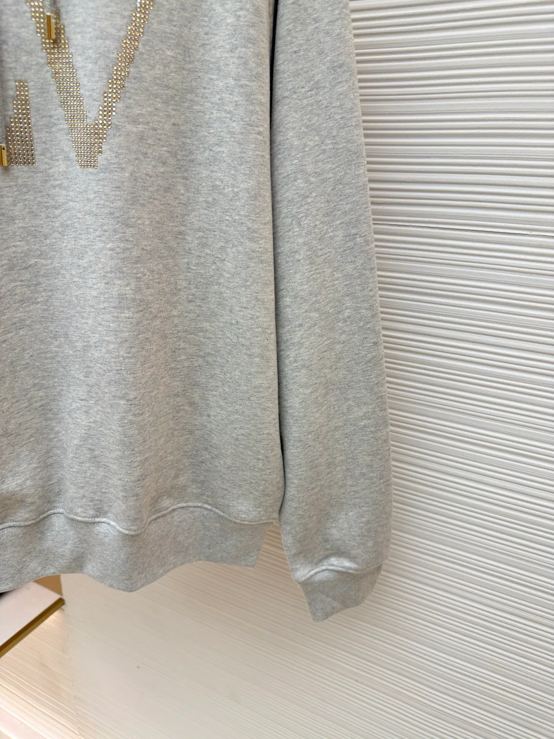 LOUIS VUITTON hooded sweatshirt with diamond letters ●Original version: Purchased and developed for 12999 ●Item number: 1680721-A75 ●Fabric: Pure cotton fish scale base fabric ●Technology: Decorated with rhinestone brand elements ●Version: Fitted version ●Weight: about 660 grams ●Size: S-M-L-XL ●Description: The fabric is made of 16S double yarn + 10S fish scale bottom brushed fabric, 380g, with 26S double yarn rib fabric 470g. The terry terry sweatshirt is composed of a veil, binding yarn and base yarn. Taking into account both breathability and comfort, the overall design is light, comfortable and has a good silhouette. It is characterized by soft feel, solid texture, and excellent extensibility, elasticity, wrinkle resistance, and hygroscopicity. Enlarge the classic letter rhinestone as a decorative element to enhance the sense of luxury and recognition. The surface is densely inlaid with rhinestones, forming a bright halo; the three-dimensional convex inlay effect enhances the visual impact. Rhinestone is a man-made gemstone that enhances the sophistication of designs with its sparkling luster. Laineite is a synthetic gemstone with high transparency and luster, creating a sparkling and three-dimensional print effect. The number and position of the particles on the plate are exactly the same, so that the graphics remain consistent with the original renderings. Precisely positioned laser engraving ensures a symmetrical arrangement of rhinestones; high temperature embeds the rhinestones on the surface of the fabric to increase firmness. The overall wiring is straight and delicate, the fabric is comfortable and soft, and the color is consistent without color difference. It can be matched with the same style to create a fashionable look and control various occasions. Customized accessories, complete with three standards, same style for men and women!